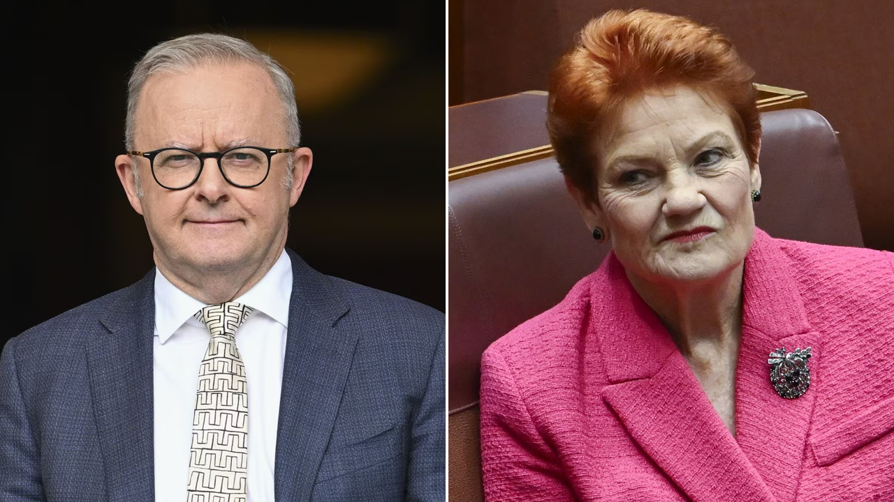 Two politicians side by side: a man in a dark suit and glasses on the left, and a woman in a pink blazer with a brooch on the right.
