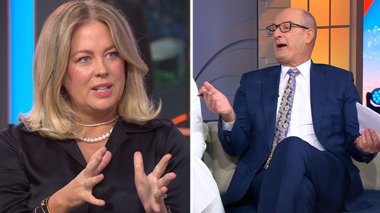 Split-screen scene of a TV talk show: left, a blonde woman in a black blazer speaking; right, a man in a blue suit gesturing while seated.