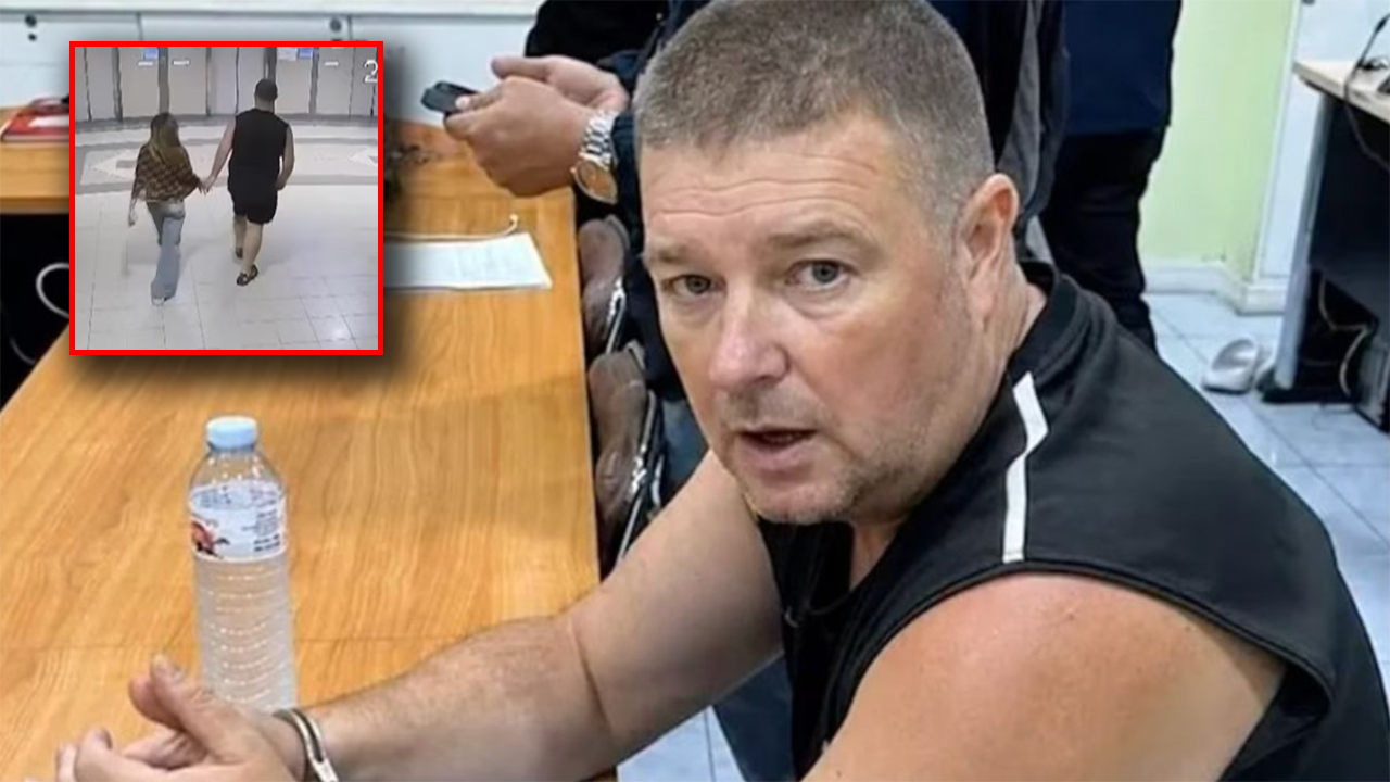 Man in a sleeveless shirt sits at a wooden table; inset shows a couple holding hands and walking in a hallway (security footage).