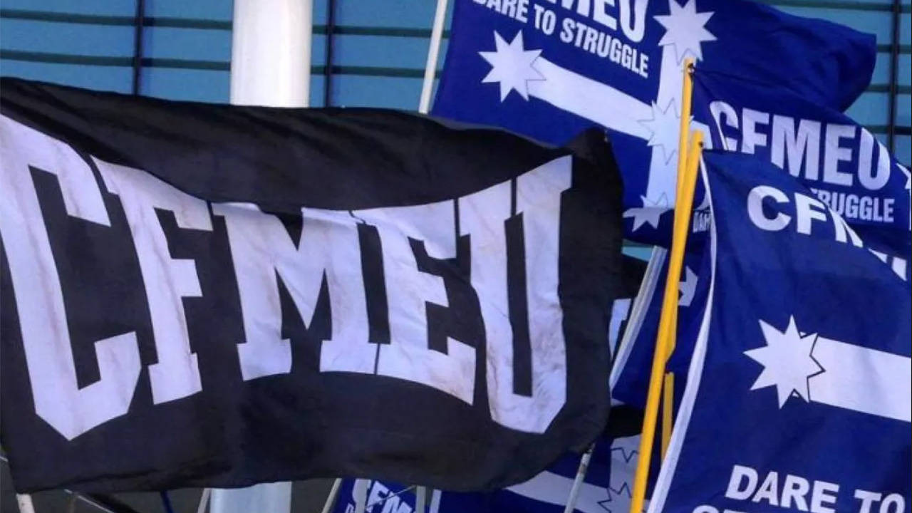 Flag banners for CFMEU union, black and blue with bold white letters and slogans like 'Dare to Struggle' in a protest setting